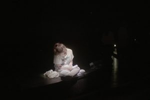 בחורה יושבת בחשכה