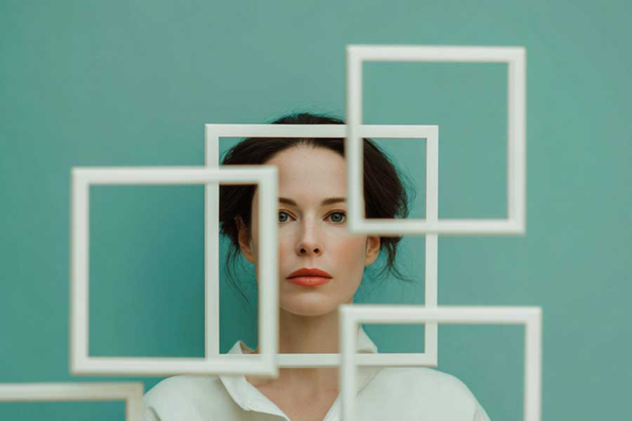 תמונת אישה שנראית מבעד למסגרות תמונה ריקות