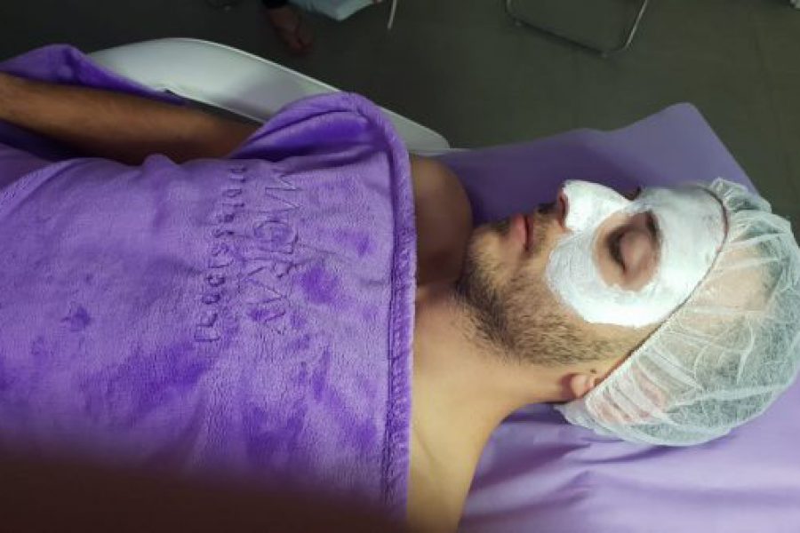 גבר עם מסיכת פנים שוכב במיטת טיפולים