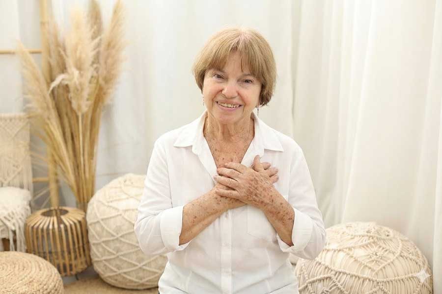 אישה מחייכת עם חולצה לבנה - יהודית שחורי