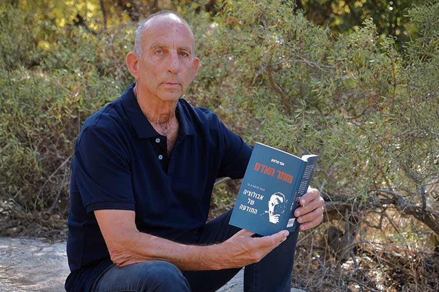 הסופר אסף סולומון מחזיק את ספרו