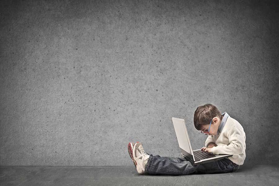 ילד מחזיק מחשב נייד על ברכיו