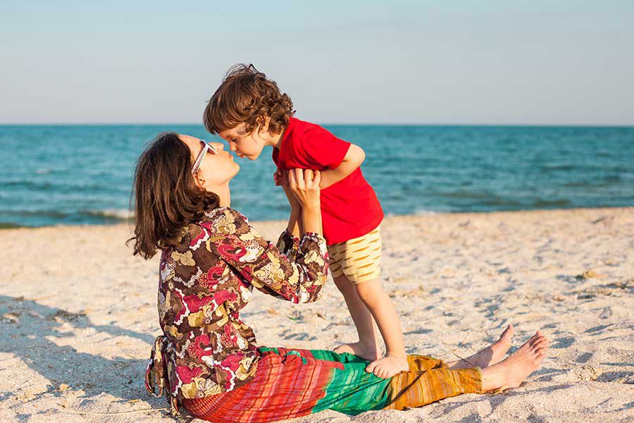 אמא מנשקת את ילדה בחוף הים