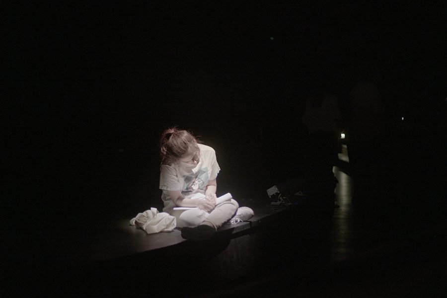 בחורה יושבת בחשכה