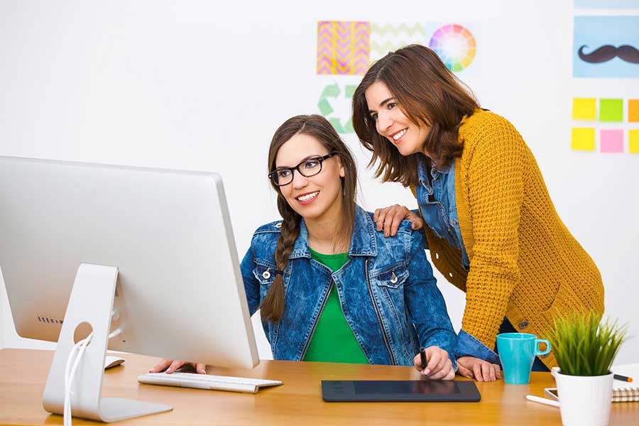 שתי נשים מביטות במסך מחשב אחד