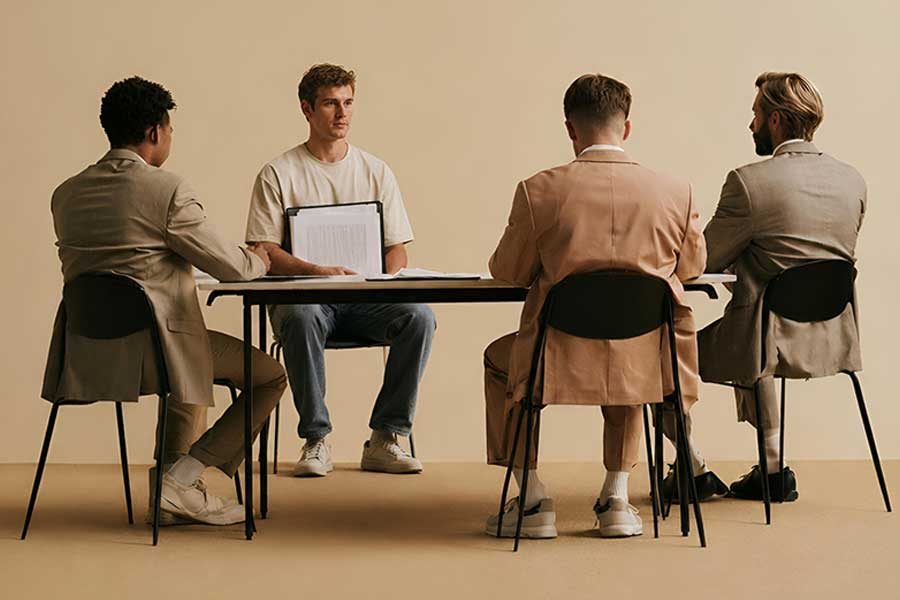 בחור יושב מול אנשים ארמן חומנקר עורך דין