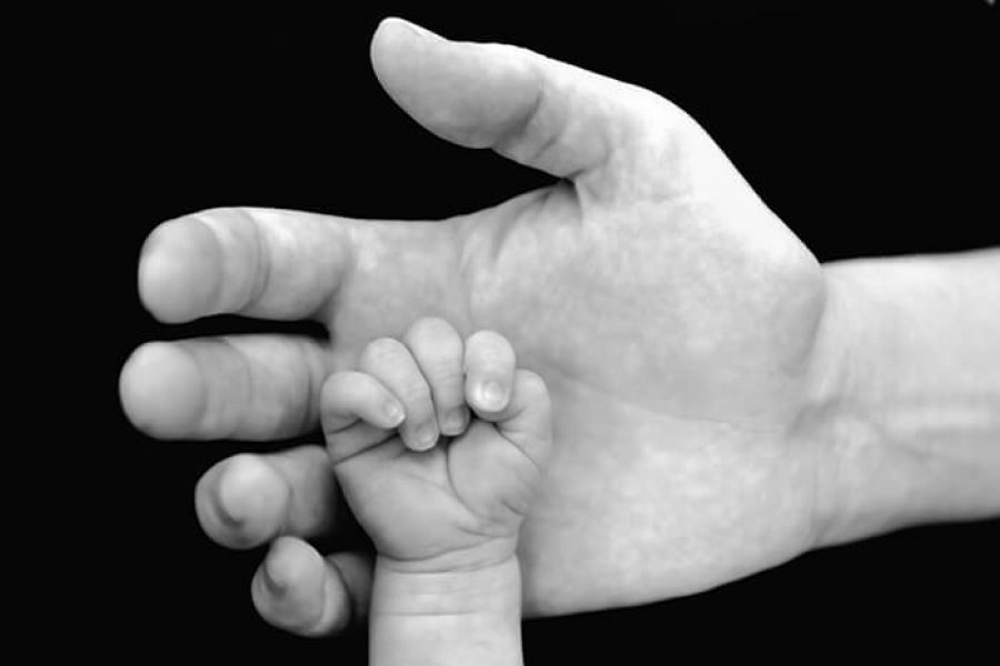 כף יד תינוק על כף יד מבוגר
