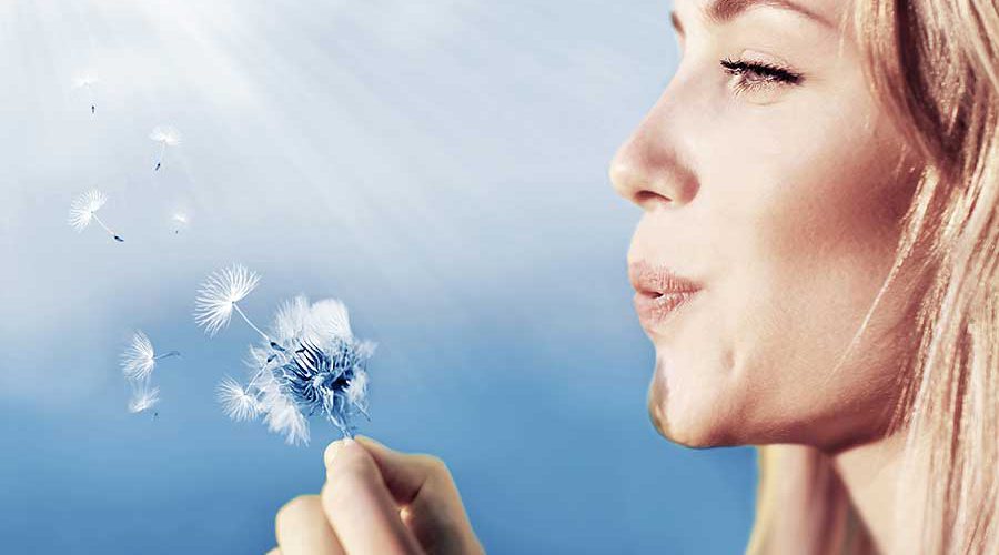 אישה נושפת על פרח