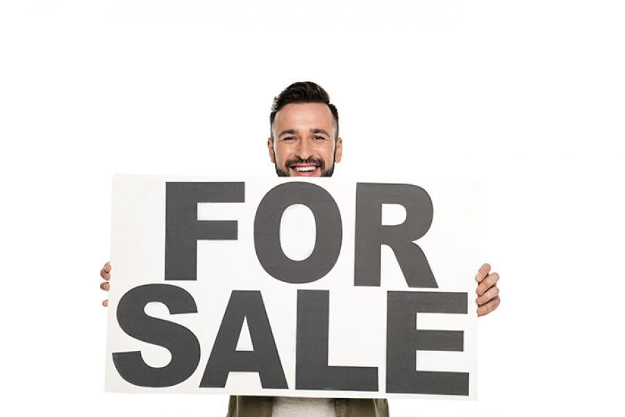 גבר מחזיק שלט כיתוב for sale
