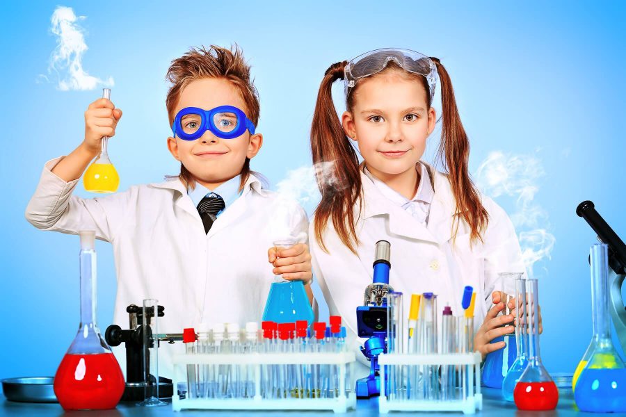ילד וילדה לבושים כמדענים במעבדה