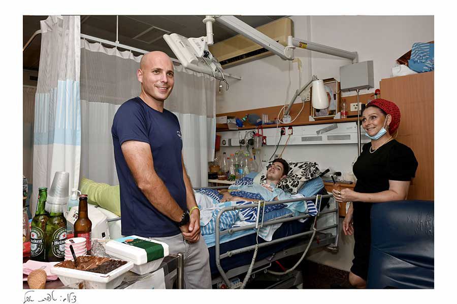 בחור ובחורה מבקרים חולה במיטת בית חולים